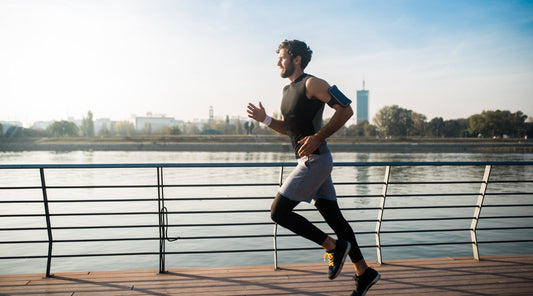 Mann joggt am Flussufer bei Sonnenschein