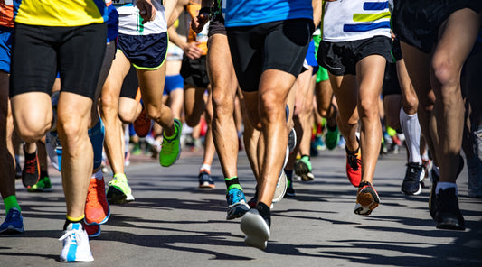 Läuferbeine bei Straßenlauf Marathon in Bewegung Nahaufnahme