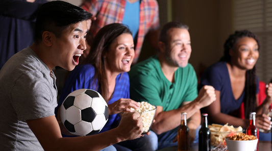 Freunde schauen Fußball gemeinsam, Fans jubeln mit Snacks und Getränken