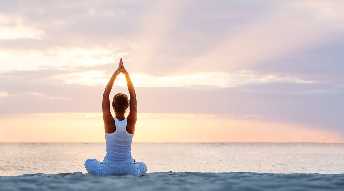 Frau streckt sich vor dem Fenster beim Yoga am Morgen