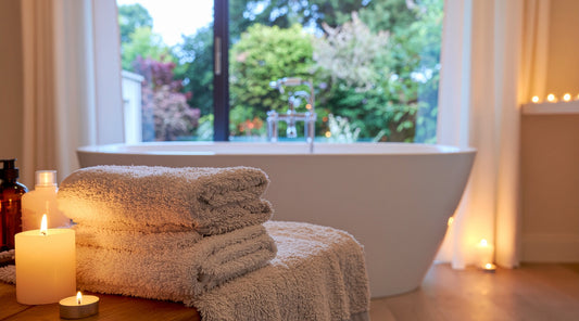 Modernes Badezimmer mit Badewanne Kerzen und Handtüchern