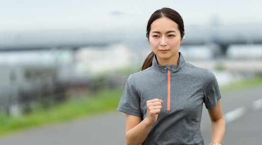 Junge Frau joggt konzentriert im Freien