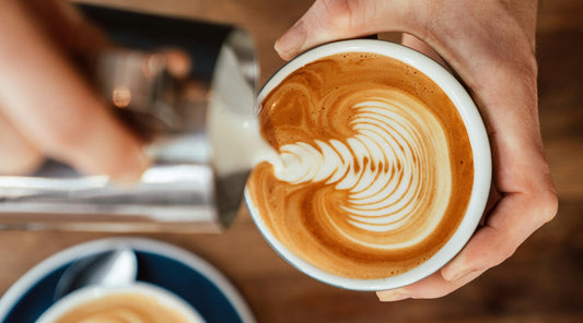Latte Art wird in eine Tasse Kaffee gegossen