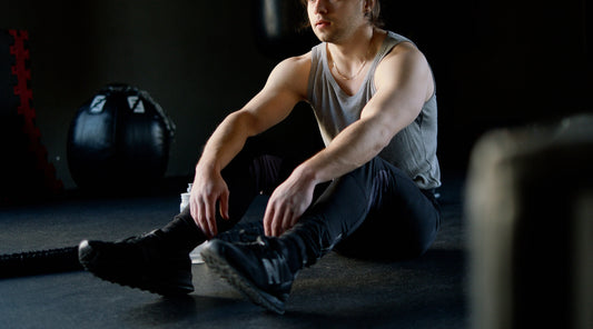 Mann erholt sich nach dem Training im Fitnessstudio