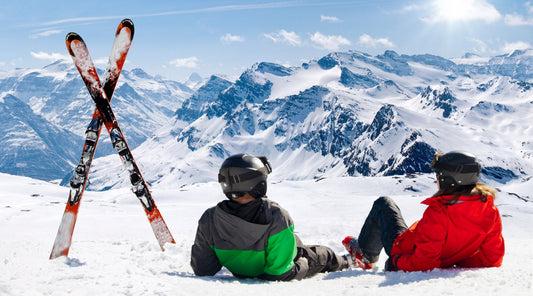 Zwei Skifahrer fahren eine verschneite Piste hinab