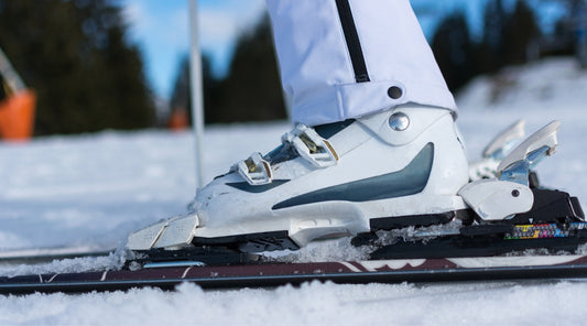 Nahaufnahme Skistiefel in Skibindung auf verschneiter Piste