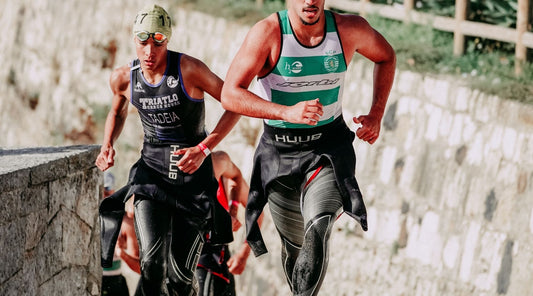 Triathleten im Neoprenanzug beim Wechsel vom Schwimmen zum Rad – intensive Wettkampfphase