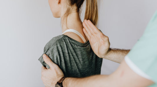 Physiotherapeut hilft junger Frau bei der Korrektur ihrer Schultern zur Haltungstherapie Wirbelsäule